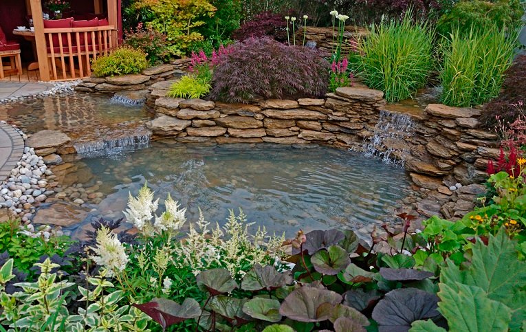 The pond area and terrace with Summer House in an aquatic garden
